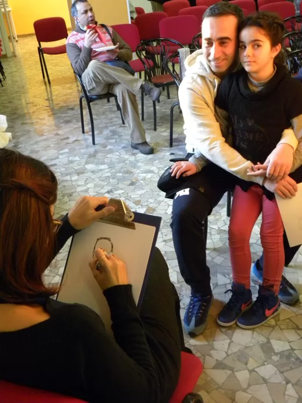 La caricaturista che si appresta a ritrarre un donatore con sua figlia